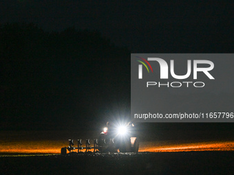 FONTENAY-LE-PESNEL, FRANCE - OCTOBER 11: 
A tractor plows the field with a heavy plough on an October night near Fontenay-le-Pesnel, Calvado...