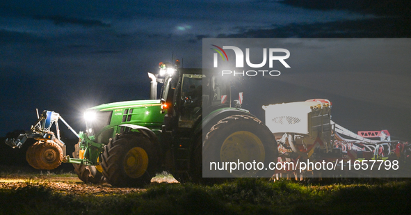 FONTENAY-LE-PESNEL, FRANCE - OCTOBER 11: 
A tractor John Deere 6250R pulls the AEROSEM POTTINGER pneumatic seed drill through a field near F...