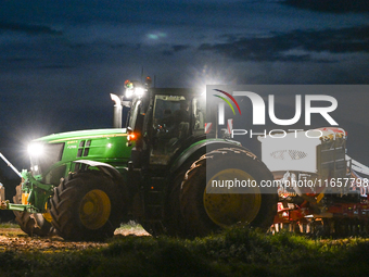 FONTENAY-LE-PESNEL, FRANCE - OCTOBER 11: 
A tractor John Deere 6250R pulls the AEROSEM POTTINGER pneumatic seed drill through a field near F...