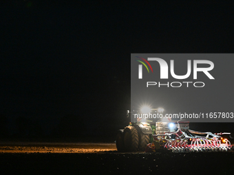 FONTENAY-LE-PESNEL, FRANCE - OCTOBER 11: 
A tractor John Deere 6250R pulls the AEROSEM POTTINGER pneumatic seed drill through a field near F...