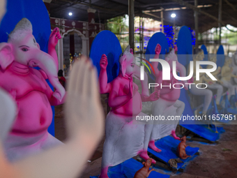 Artisans prepare idols of Lord Ganesha in vibrant shades of pink and blue for the Sharadiya Durga Puja festival in Bangladesh. Their detaile...