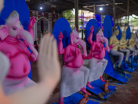 Artisans prepare idols of Lord Ganesha in vibrant shades of pink and blue for the Sharadiya Durga Puja festival in Bangladesh. Their detaile...