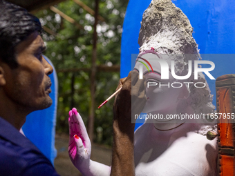 An artisan works on an idol of the Hindu goddess Durga at a workshop ahead of the Durga Puja festival in Dhaka, Bangladesh, on October 4, 20...