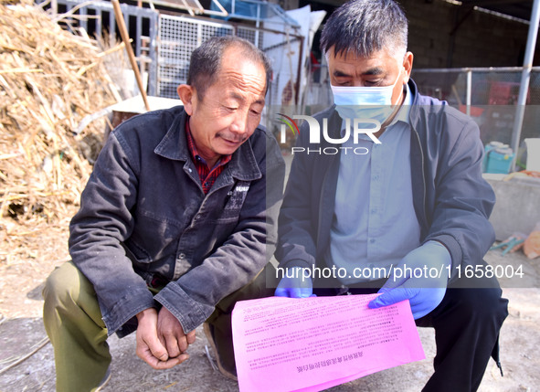 A staff member of a livestock station in Quanzhen town propagates knowledge about animal and poultry epidemic prevention to farmers in Damaw...