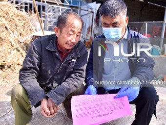 A staff member of a livestock station in Quanzhen town propagates knowledge about animal and poultry epidemic prevention to farmers in Damaw...