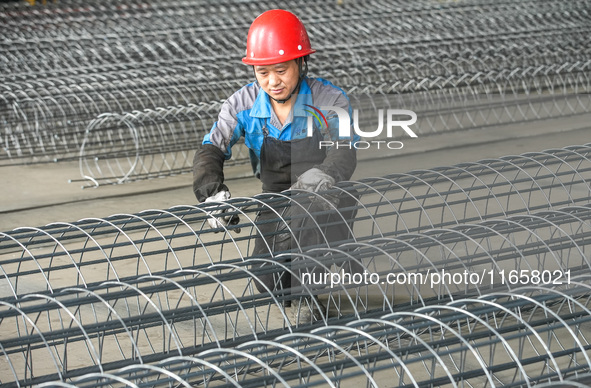 A worker makes concrete pipe pile products in Huzhou, China, on October 12, 2024. 