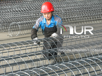 A worker makes concrete pipe pile products in Huzhou, China, on October 12, 2024. (