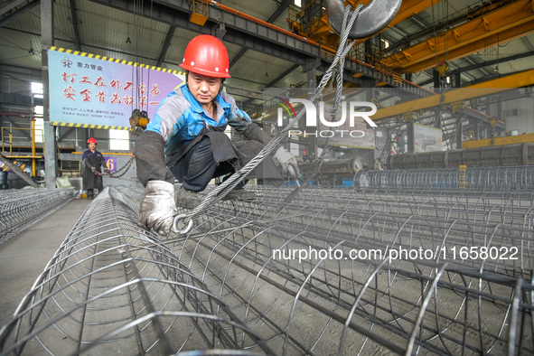 A worker makes concrete pipe pile products in Huzhou, China, on October 12, 2024. 