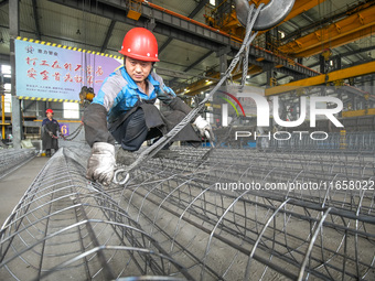 A worker makes concrete pipe pile products in Huzhou, China, on October 12, 2024. (