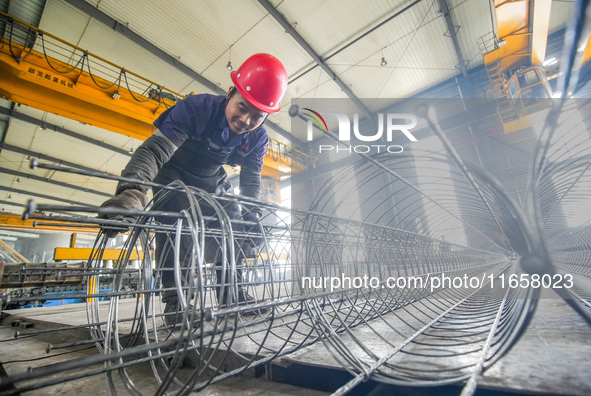 A worker makes concrete pipe pile products in Huzhou, China, on October 12, 2024. 