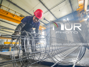 A worker makes concrete pipe pile products in Huzhou, China, on October 12, 2024. (