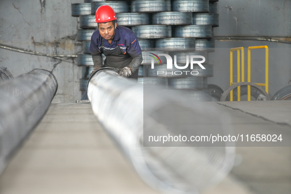 A worker makes concrete pipe pile products in Huzhou, China, on October 12, 2024. 