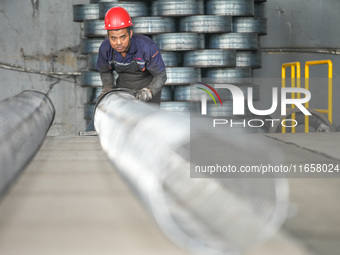 A worker makes concrete pipe pile products in Huzhou, China, on October 12, 2024. (