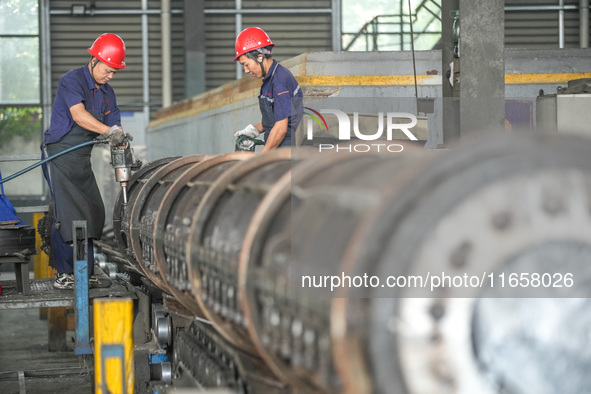 A worker makes concrete pipe pile products in Huzhou, China, on October 12, 2024. 