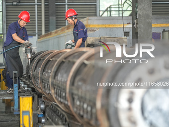 A worker makes concrete pipe pile products in Huzhou, China, on October 12, 2024. (