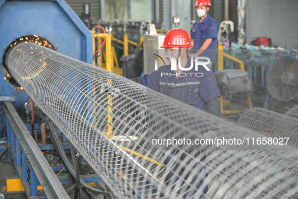 A worker makes concrete pipe pile products in Huzhou, China, on October 12, 2024. 