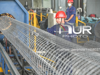 A worker makes concrete pipe pile products in Huzhou, China, on October 12, 2024. (