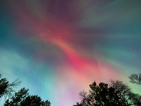 The Aurora Borealis, or Northern Lights, is visible over Chisago City, Minnesota, due to a major geomagnetic storm and heightened solar acti...