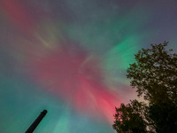 The Aurora Borealis, or Northern Lights, is visible over Chisago City, Minnesota, due to a major geomagnetic storm and heightened solar acti...