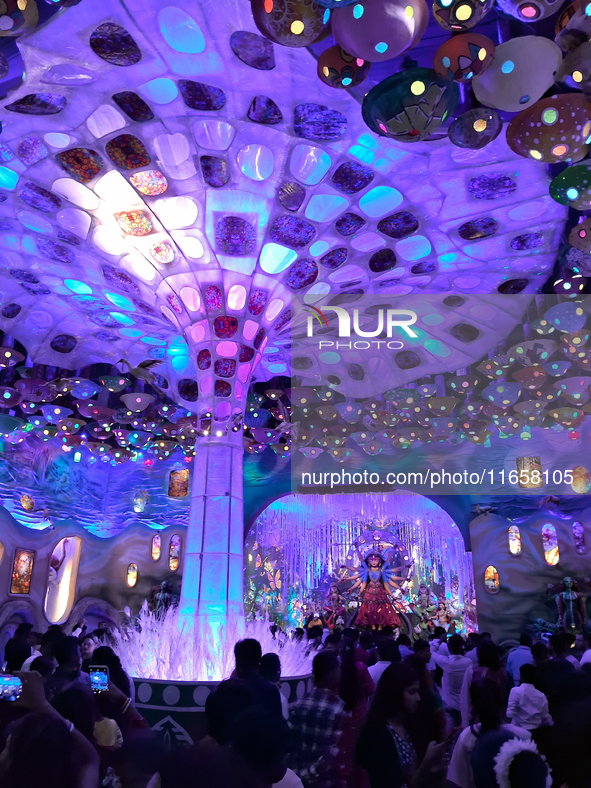 Devotees visit the puja pandal where the idol of Hindu Goddess 'Durga' is worshiped during the Durga Puja festival celebrations in Siliguri,...