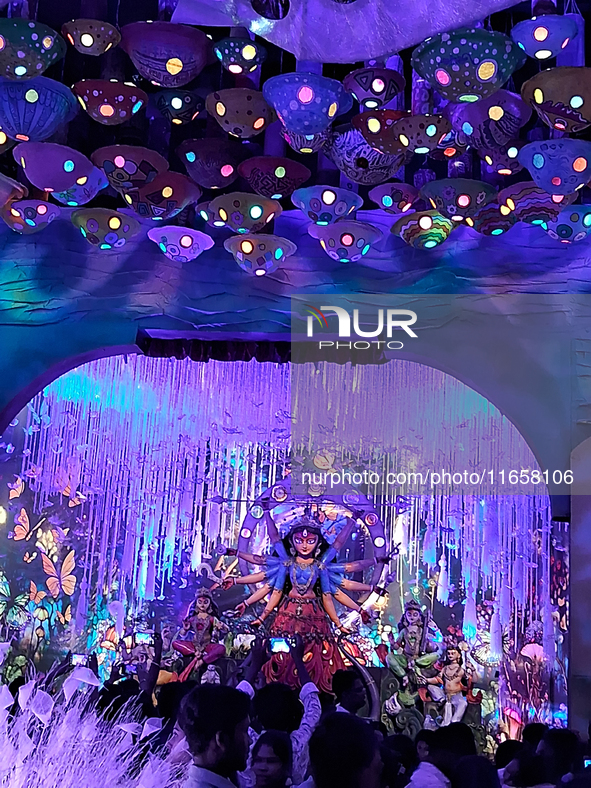 Devotees visit the puja pandal where the idol of Hindu Goddess 'Durga' is worshiped during the Durga Puja festival celebrations in Siliguri,...