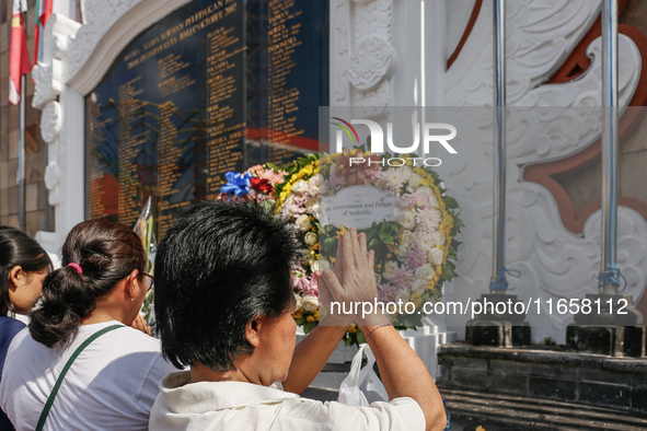 Relatives of the victims of the 2002 Bali bombings pray in front of the Bali Bombing Memorial during the 22nd commemoration of the attacks i...