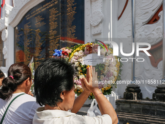 Relatives of the victims of the 2002 Bali bombings pray in front of the Bali Bombing Memorial during the 22nd commemoration of the attacks i...