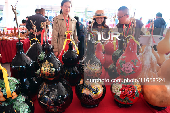 Visitors buy craft gourds at the Gourd Culture and Art Festival in Liaocheng, China, on October 12, 2024. 