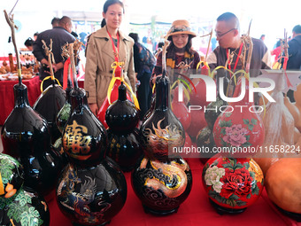 Visitors buy craft gourds at the Gourd Culture and Art Festival in Liaocheng, China, on October 12, 2024. (