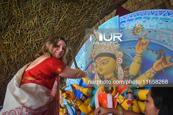 A foreigner performs rituals to an idol of the Hindu goddess Durga while offering prayers on the last day of the Durga Puja festival in Kolk...