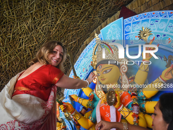 A foreigner performs rituals to an idol of the Hindu goddess Durga while offering prayers on the last day of the Durga Puja festival in Kolk...