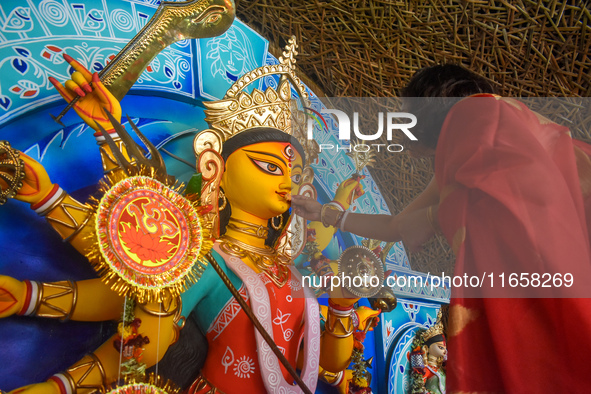 A woman offers sweets to an idol of the Hindu goddess Durga while offering prayers on the last day of the Durga Puja festival in Kolkata, In...