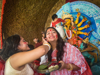 Hindu women apply ''sindhur,'' or vermillion powder, on each other's faces after worshipping the idol of the Hindu goddess Durga on the last...