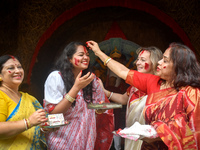 Hindu women apply ''sindhur,'' or vermillion powder, on each other's faces after worshipping the idol of the Hindu goddess Durga on the last...