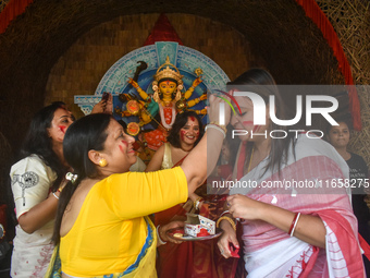 Hindu women apply ''sindhur,'' or vermillion powder, on each other's faces after worshipping the idol of the Hindu goddess Durga on the last...