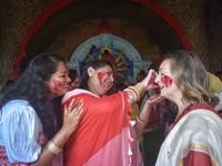 Hindu women apply ''sindhur,'' or vermillion powder, to a foreigner's face after worshipping the idol of the Hindu goddess Durga on the last...