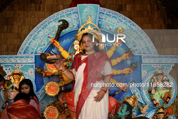 A woman stands in front of a Durga idol after worshipping the idol of the Hindu goddess Durga on the last day of the Durga Puja festival in...