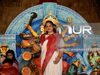 A woman stands in front of a Durga idol after worshipping the idol of the Hindu goddess Durga on the last day of the Durga Puja festival in...