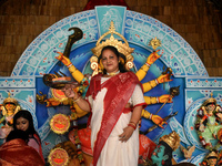 A woman stands in front of a Durga idol after worshipping the idol of the Hindu goddess Durga on the last day of the Durga Puja festival in...