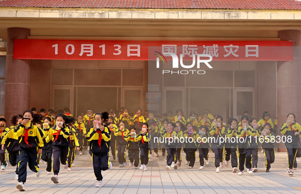 Primary school students perform an emergency escape drill in Zaozhuang, China, on October 12, 2024. 