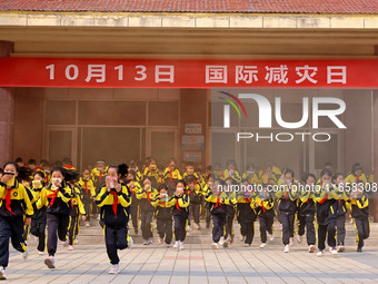 Primary school students perform an emergency escape drill in Zaozhuang, China, on October 12, 2024. (