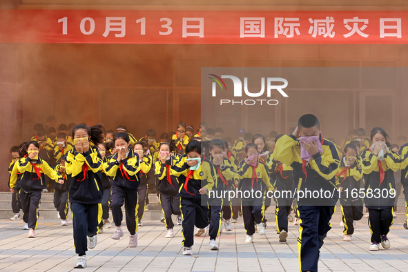 Primary school students perform an emergency escape drill in Zaozhuang, China, on October 12, 2024. 