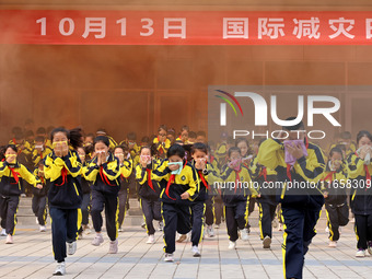 Primary school students perform an emergency escape drill in Zaozhuang, China, on October 12, 2024. (