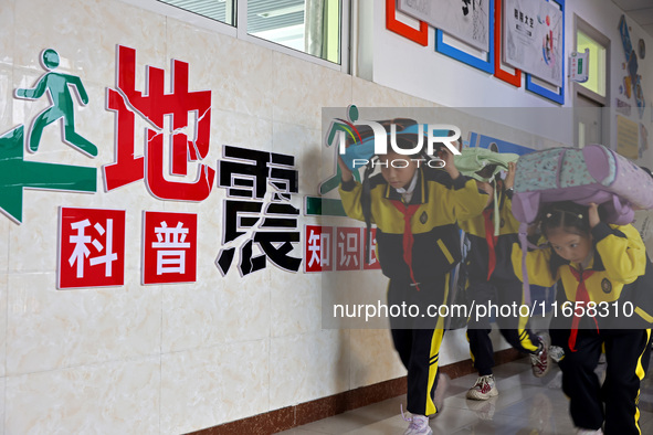 Primary school students conduct a fire emergency escape drill in Zaozhuang, China, on October 12, 2024. 