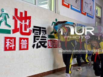 Primary school students conduct a fire emergency escape drill in Zaozhuang, China, on October 12, 2024. (