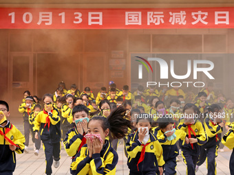 Primary school students perform an emergency escape drill in Zaozhuang, China, on October 12, 2024. (