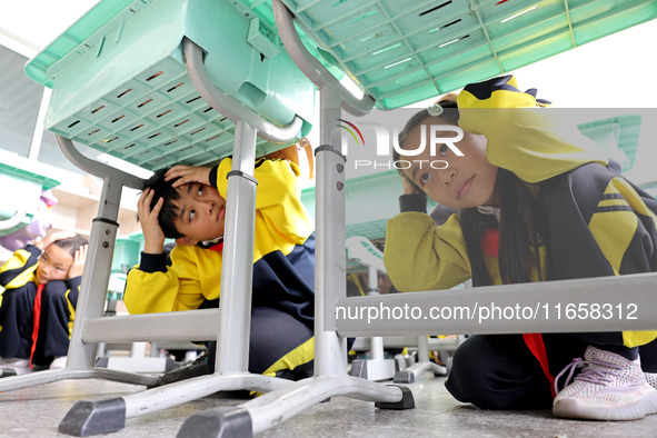 Primary school students participate in an earthquake preparedness and disaster reduction drill in Zaozhuang, China, on October 12, 2024. 