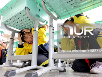 Primary school students participate in an earthquake preparedness and disaster reduction drill in Zaozhuang, China, on October 12, 2024. (