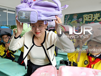 A teacher (center) teaches students about earthquake survival in Zaozhuang, China, on October 12, 2024. (