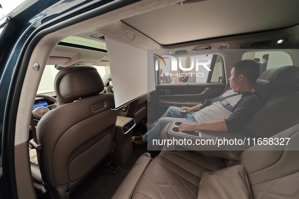 A customer experiences a new energy vehicle at Huawei's global flagship store on Nanjing Road pedestrian Street in Shanghai, China, on Octob...